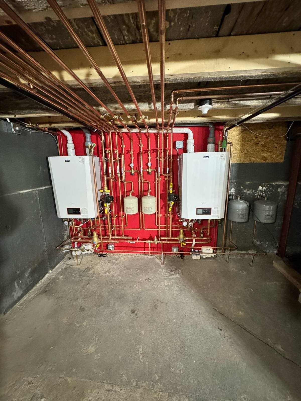 Mechanical room with boiler and water heater piping serviced by Precision Plumbing Solutions
