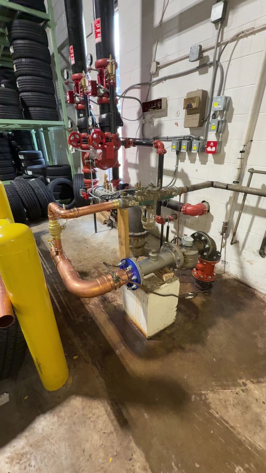Commercial mechanical room piping with backflow prevention assemblies serviced by Precision Plumbing Solutions