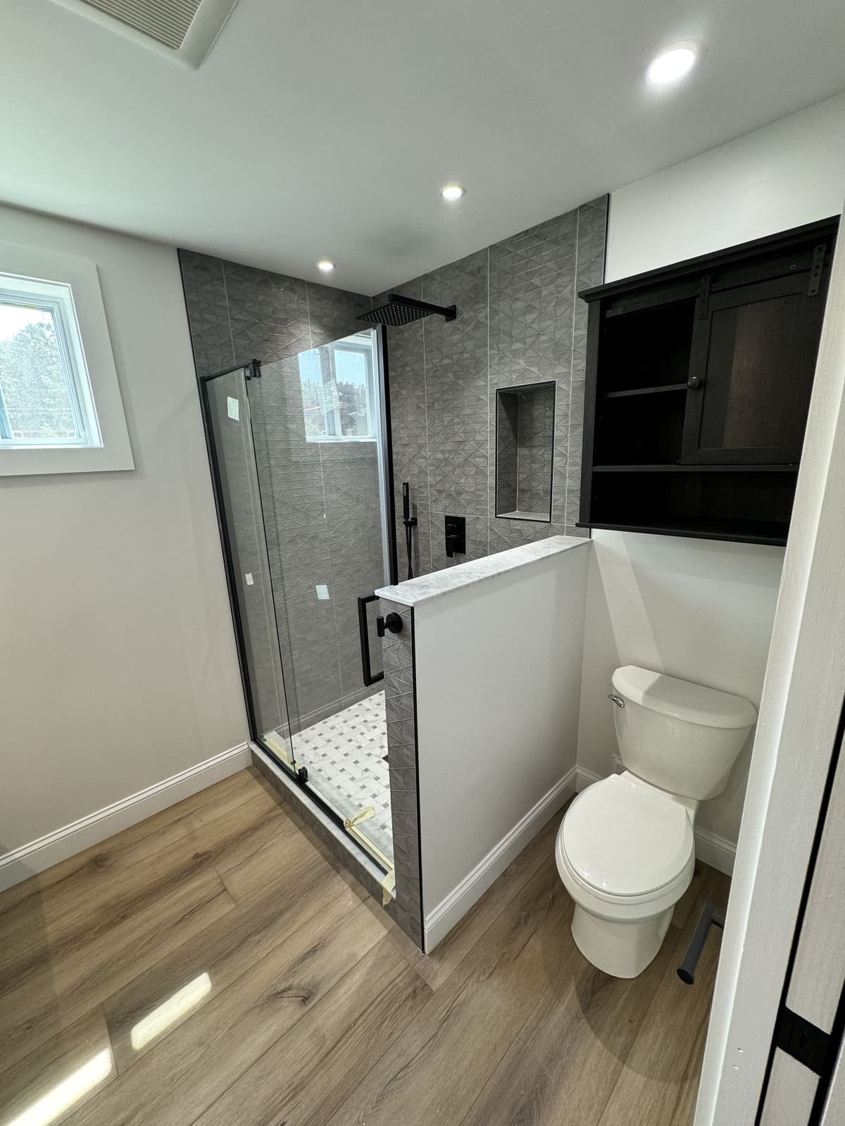 New toilet and glass shower installed during a bathroom renovation by Precision Plumbing Solutions