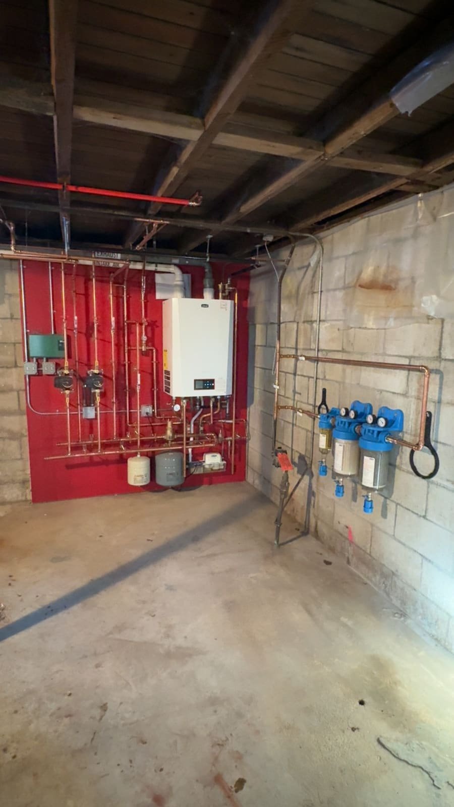 Whole-house water filtration system installed beside a boiler by Precision Plumbing Solutions