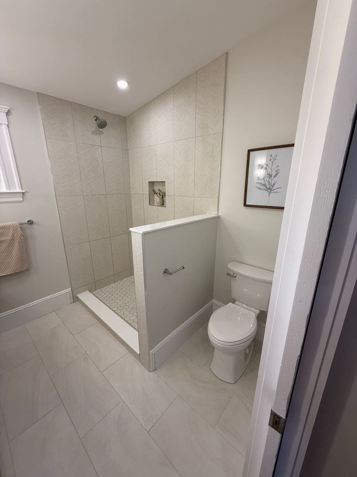 White tiled bathroom with new shower drain and fixtures installed by Precision Plumbing Solutions